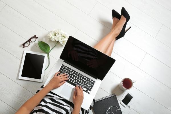 woman on floor in high heels working on laptop