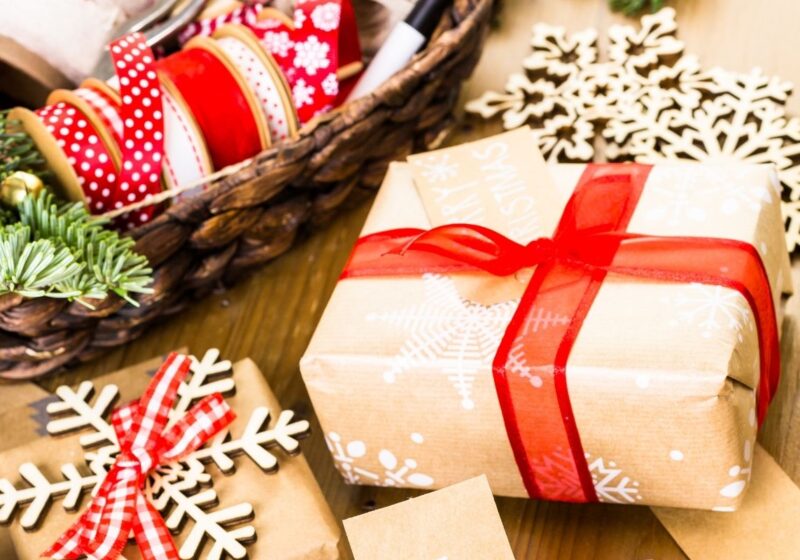 christmas gifts wrapped in brown paper with red ribbon